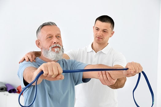 Professional physiotherapist working with senior patient in reha Senior man exercising