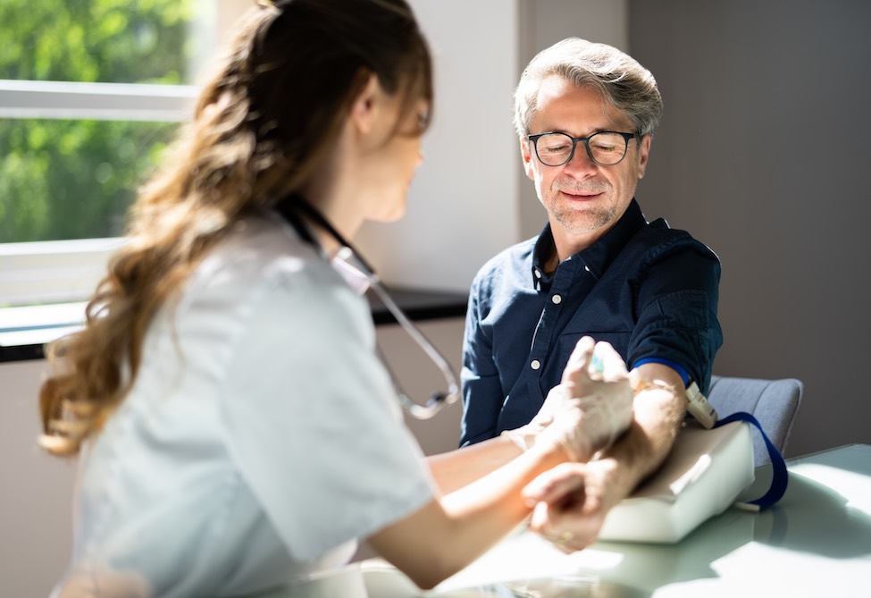 A nurse taking blood from a male patient
