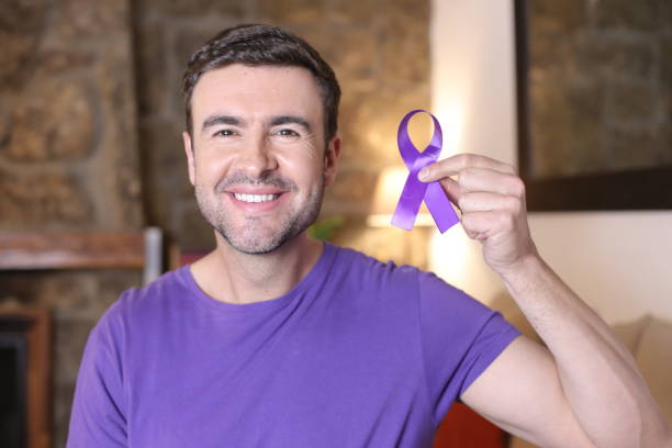 Man holding a purple ribbon.