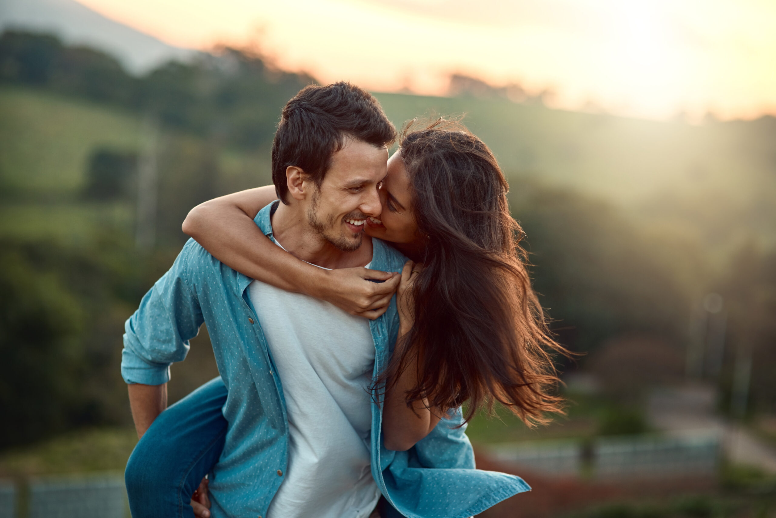 Cropped shot of a handsome young man piggybacking his girlfriend while spending some time outdoors