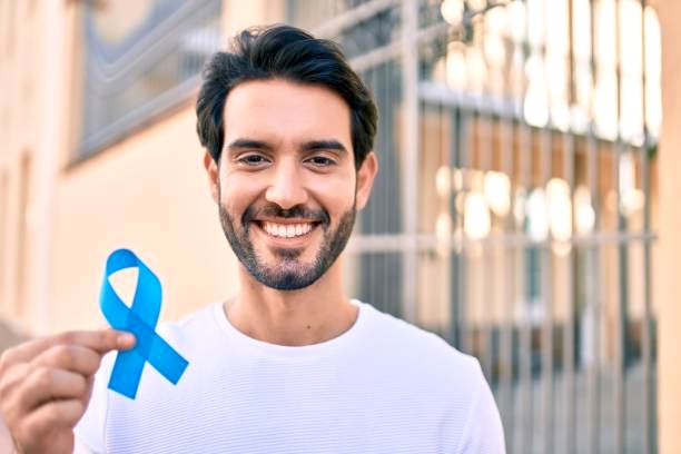 Man with Blue Ribbon in front of building