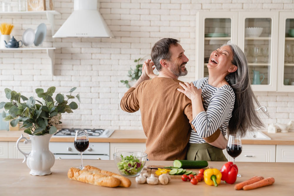 middle aged couple dancing in kitchen
